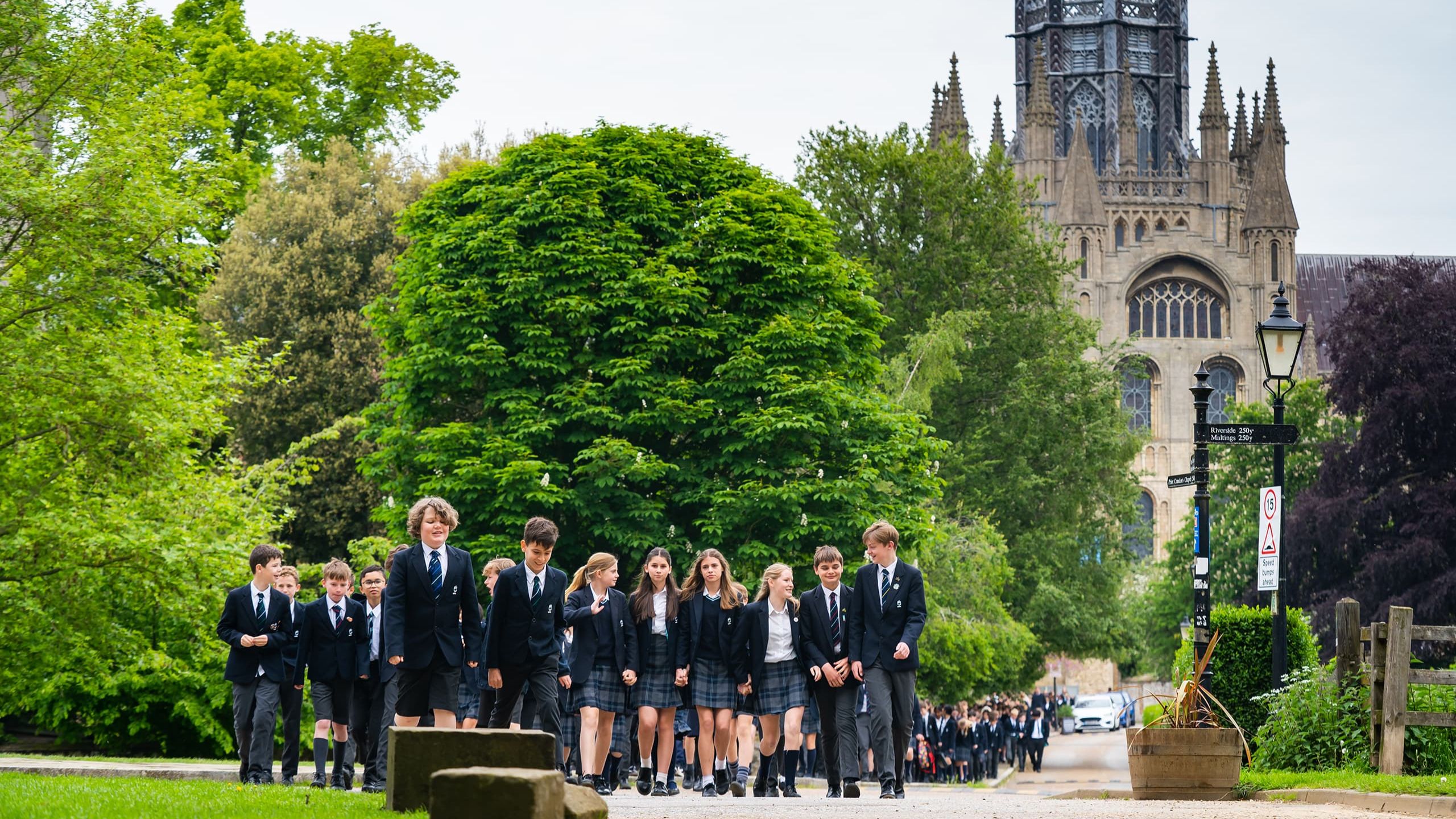 Group of King's Ely students walking outside Ely Cathedral 